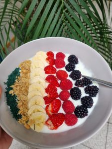 Müsli-Bowl mit Naturjoghurt, Brombeeren, Erdbeeren, Himbeeren, Bananen und feinem Spirulina-Granulat